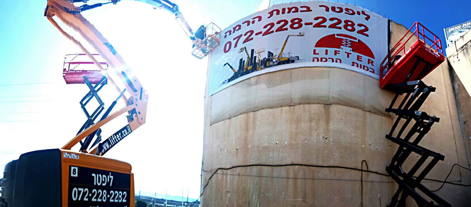 שתי במות הרמה, אחת כתובה ליפטר והשנייה מספריים, ניצבות לצד מבנה עגול עם שלט גדול.